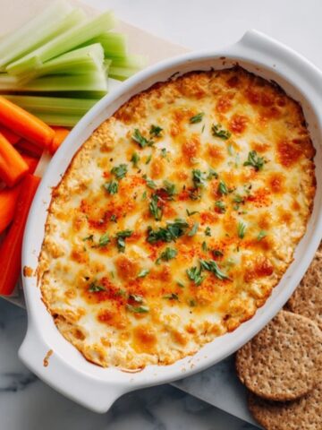 healthy buffalo chicken dip baked with golden cheese and veggies for dipping