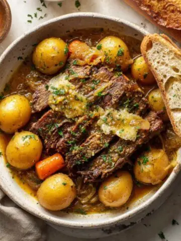 Instant Pot French Onion Pot Roast with onion gravy, potatoes, and carrots on white counter