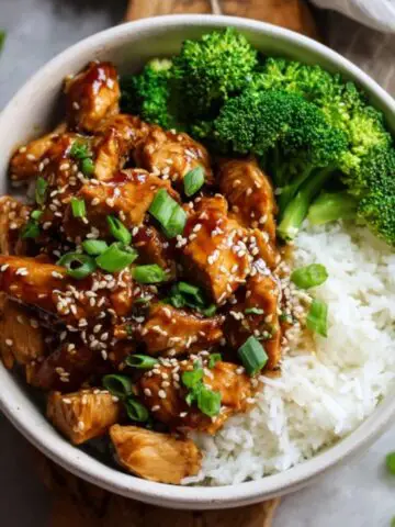 Instant Pot teriyaki chicken served over rice with sesame seeds and green onions