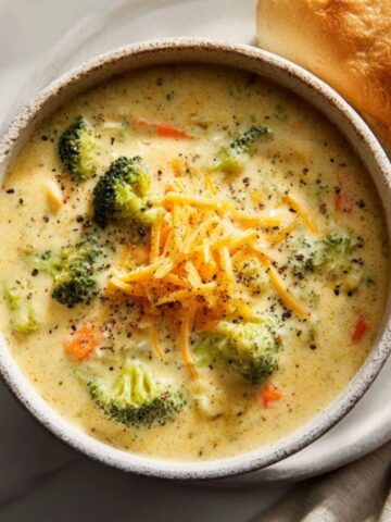 creamy panera bread broccoli cheddar soup in a bowl with bread
