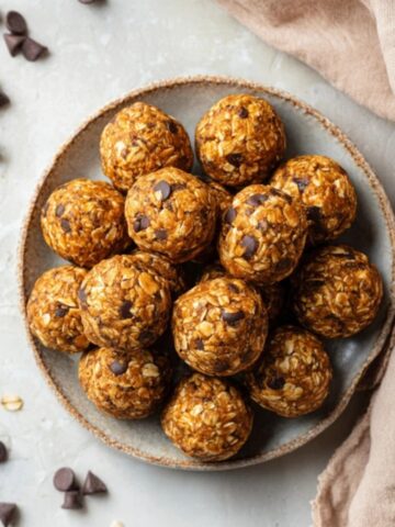 Homemade pumpkin energy bites with oats and pumpkin spice on a white kitchen counter