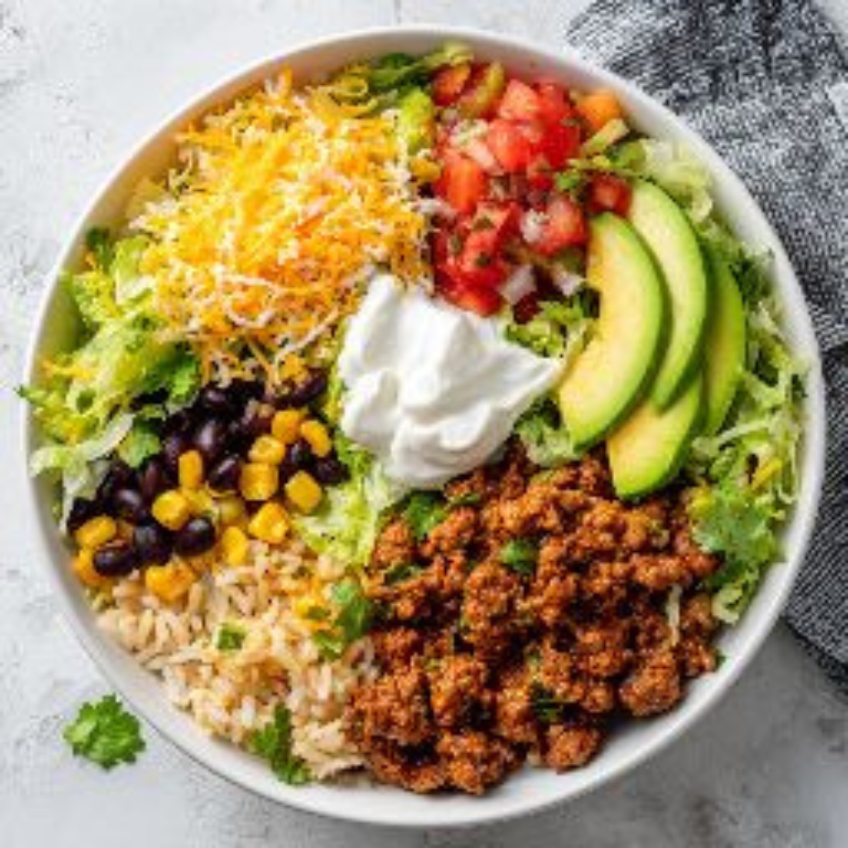 Taco rice bowl with cilantro lime rice, ground beef, beans, corn, and fresh toppings