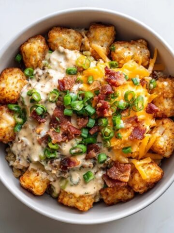 Hearty tater tot breakfast bowl with eggs, sausage gravy, and cheese