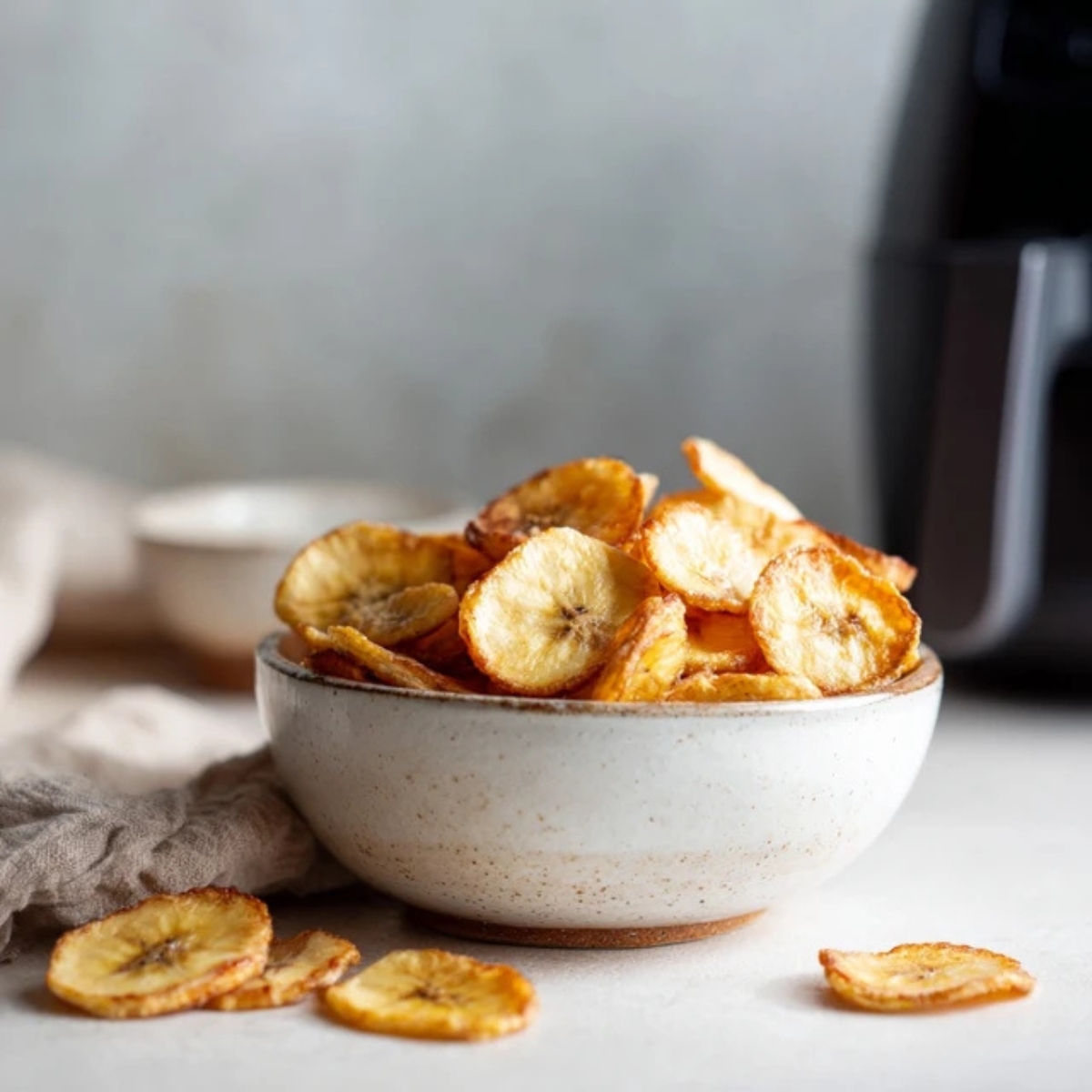 crispy homemade air fryer banana chips on white kitchen counter