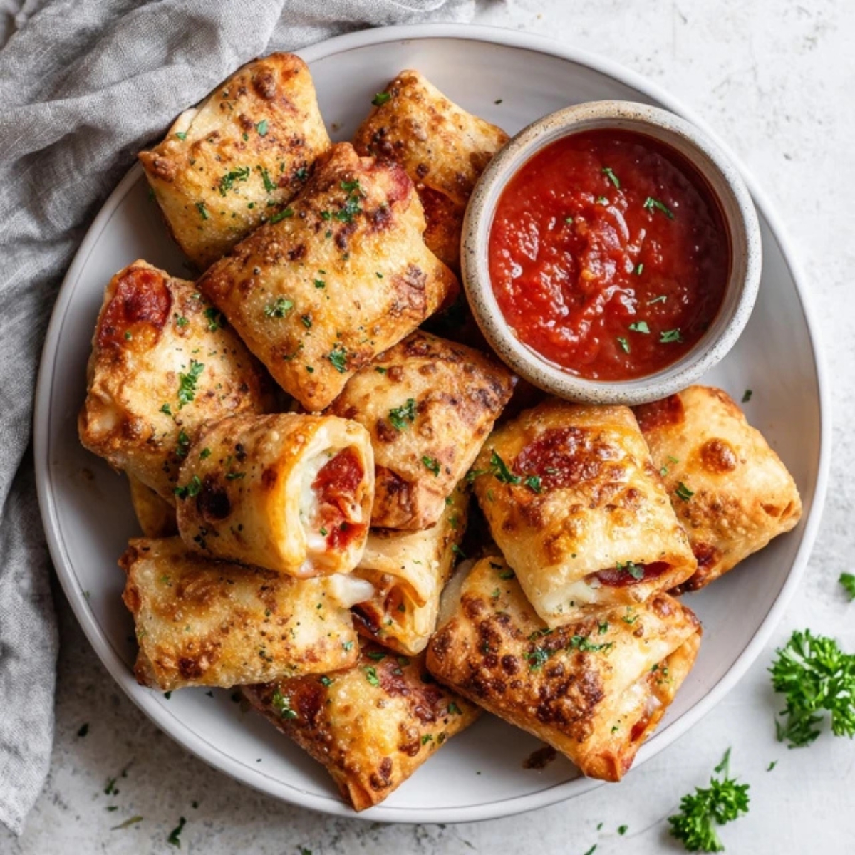 Crispy air fryer pizza rolls with melted cheese and pepperoni on white counter