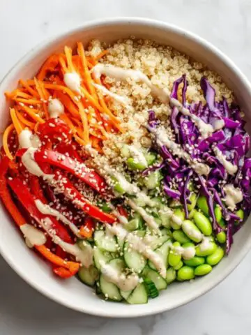 Healthy Asian quinoa bowl with sesame ginger dressing on white kitchen counter