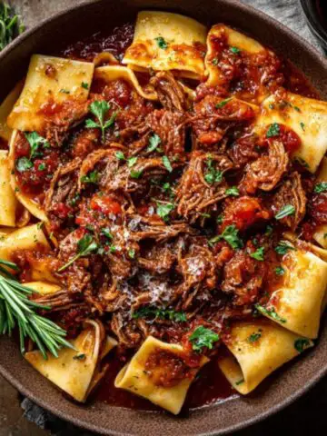 Homemade beef ragu with pappardelle pasta topped with parmesan and basil
