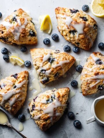 Homemade blueberry scones with lemon glaze on white kitchen counter