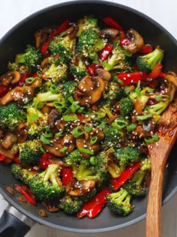 Homemade broccoli and mushroom stir fry in wok with sesame seeds