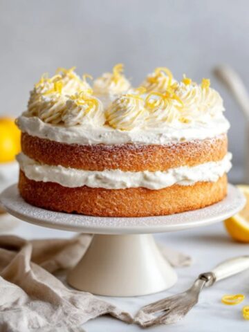 fluffy lemon cloud cake with whipped cream frosting on white kitchen counter