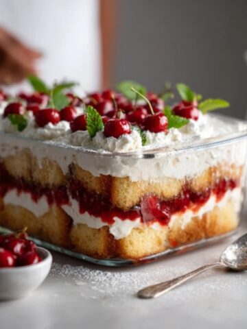 heaven on earth cake with layers of angel food cake pudding and cherries on white kitchen counter