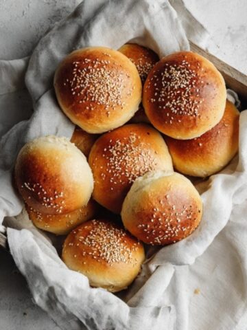 Homemade golden burger buns on a white kitchen counter