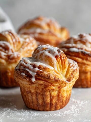 Flaky homemade cruffins with glaze on a white kitchen counter