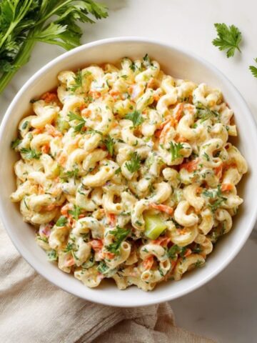 Macaroni salad ingredients arranged neatly on a white kitchen counter