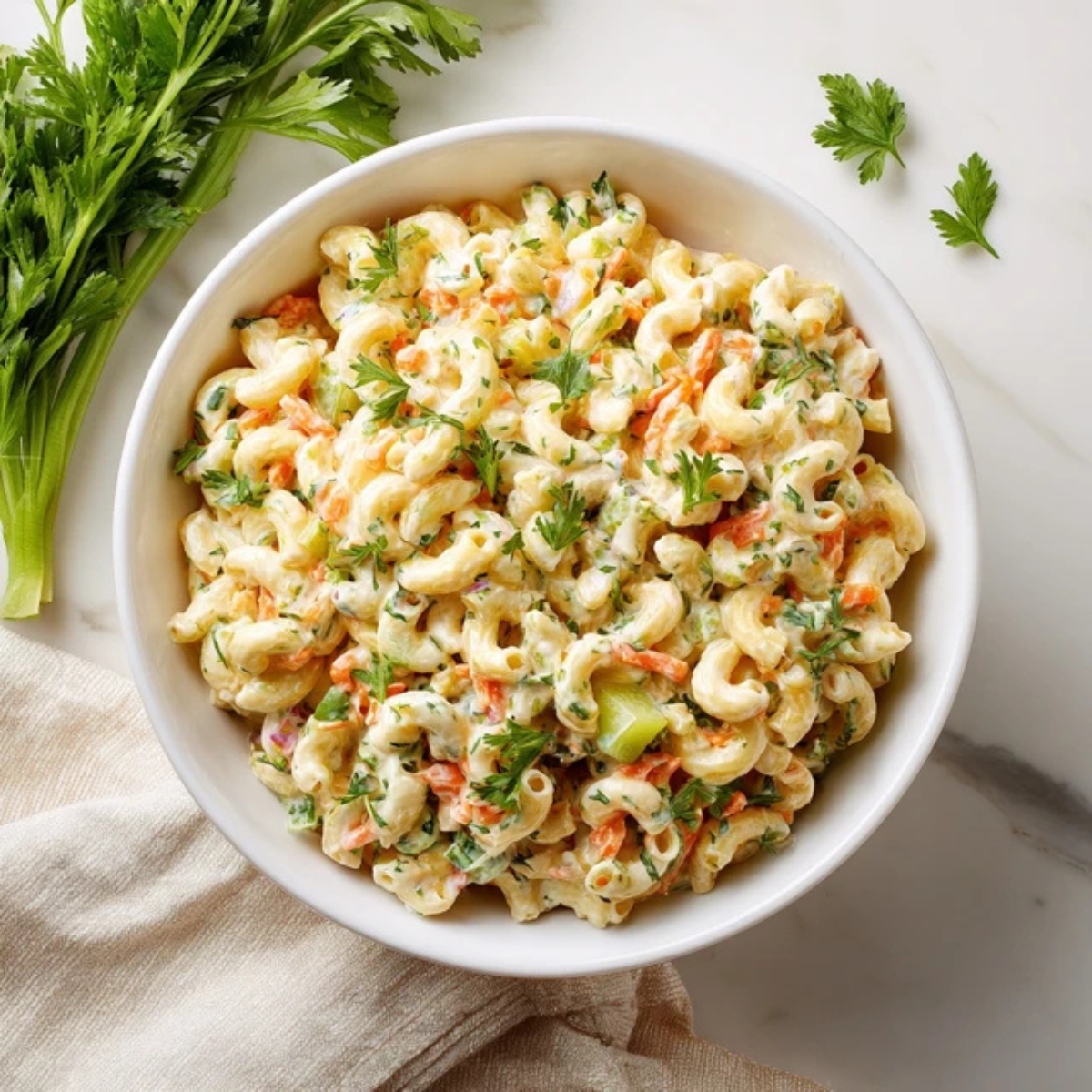Macaroni salad ingredients arranged neatly on a white kitchen counter