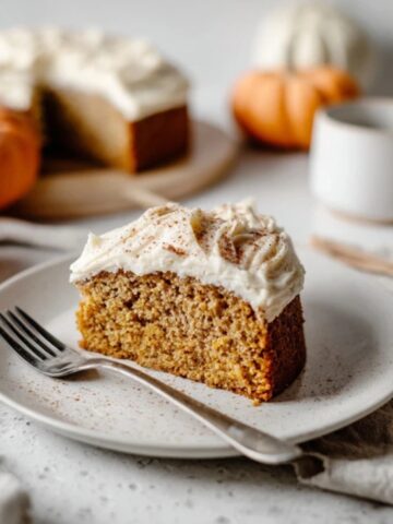 Homemade pumpkin cake with cream cheese frosting on white kitchen counter