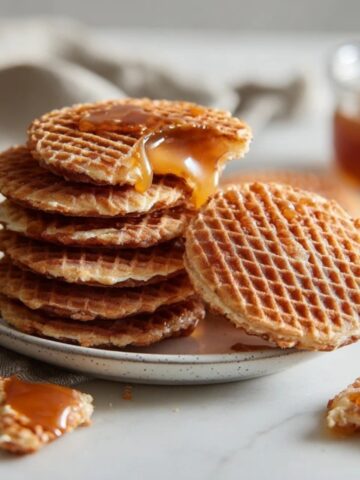 Homemade stroopwafels with gooey caramel filling on white kitchen counter