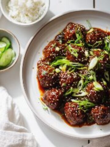 Sticky Korean BBQ meatballs with gochujang glaze and sesame seeds on a white kitchen counter