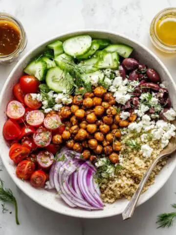Mediterranean quinoa bowl with chickpeas, feta, and lemon dressing on a white kitchen counter