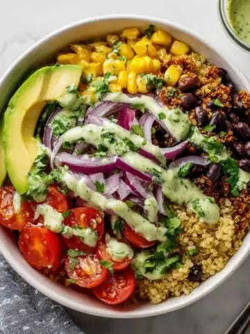 Healthy Mexican quinoa bowl with avocado and black beans on a white kitchen counter