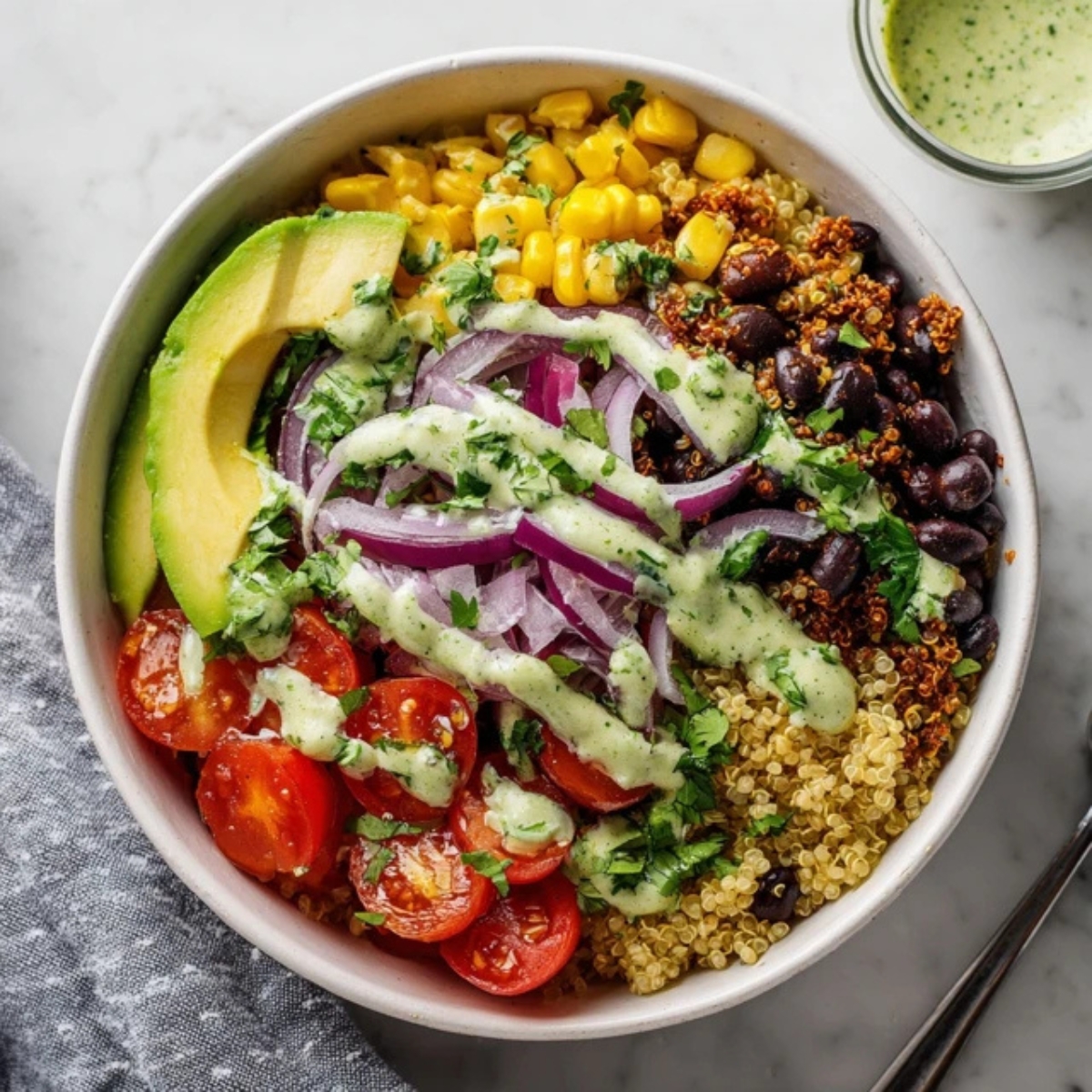 Healthy Mexican quinoa bowl with avocado and black beans on a white kitchen counter