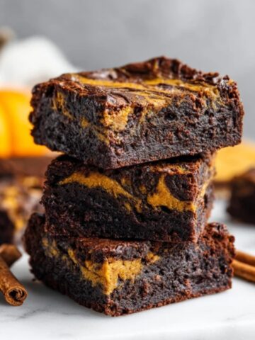 fudgy pumpkin brownies with chocolate and pumpkin swirl on white counter