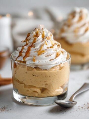 creamy pumpkin mousse dessert topped with whipped cream and cinnamon