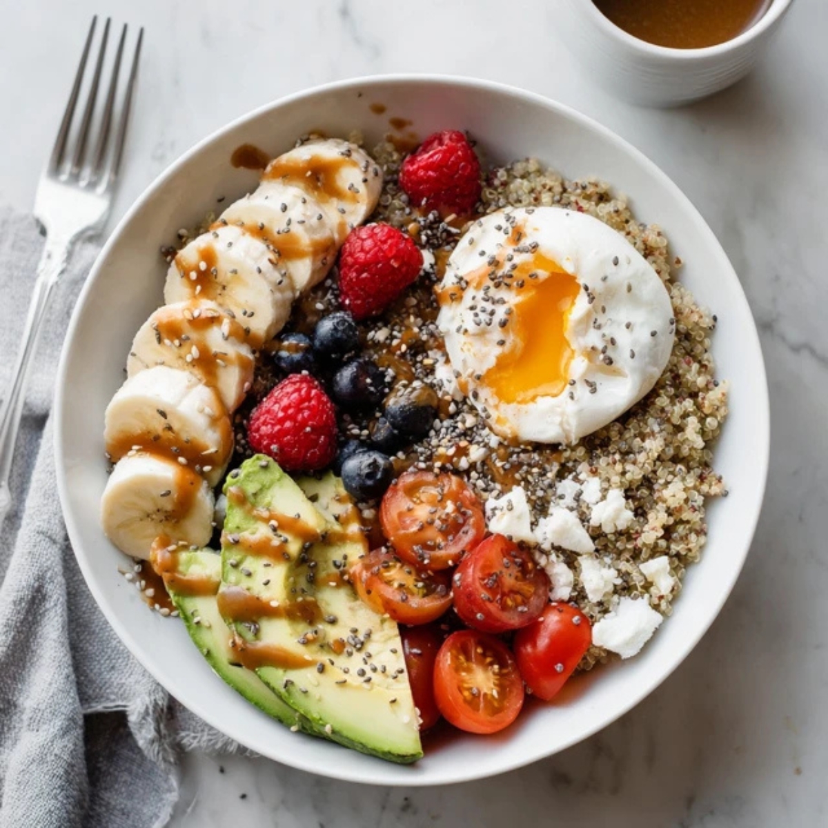 Healthy quinoa breakfast bowl with sweet and savory toppings on white kitchen counter