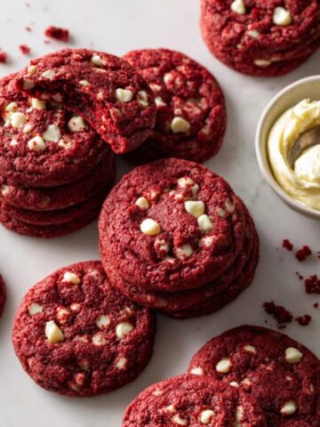Soft chewy red velvet cookies with white chocolate chips on white kitchen counter