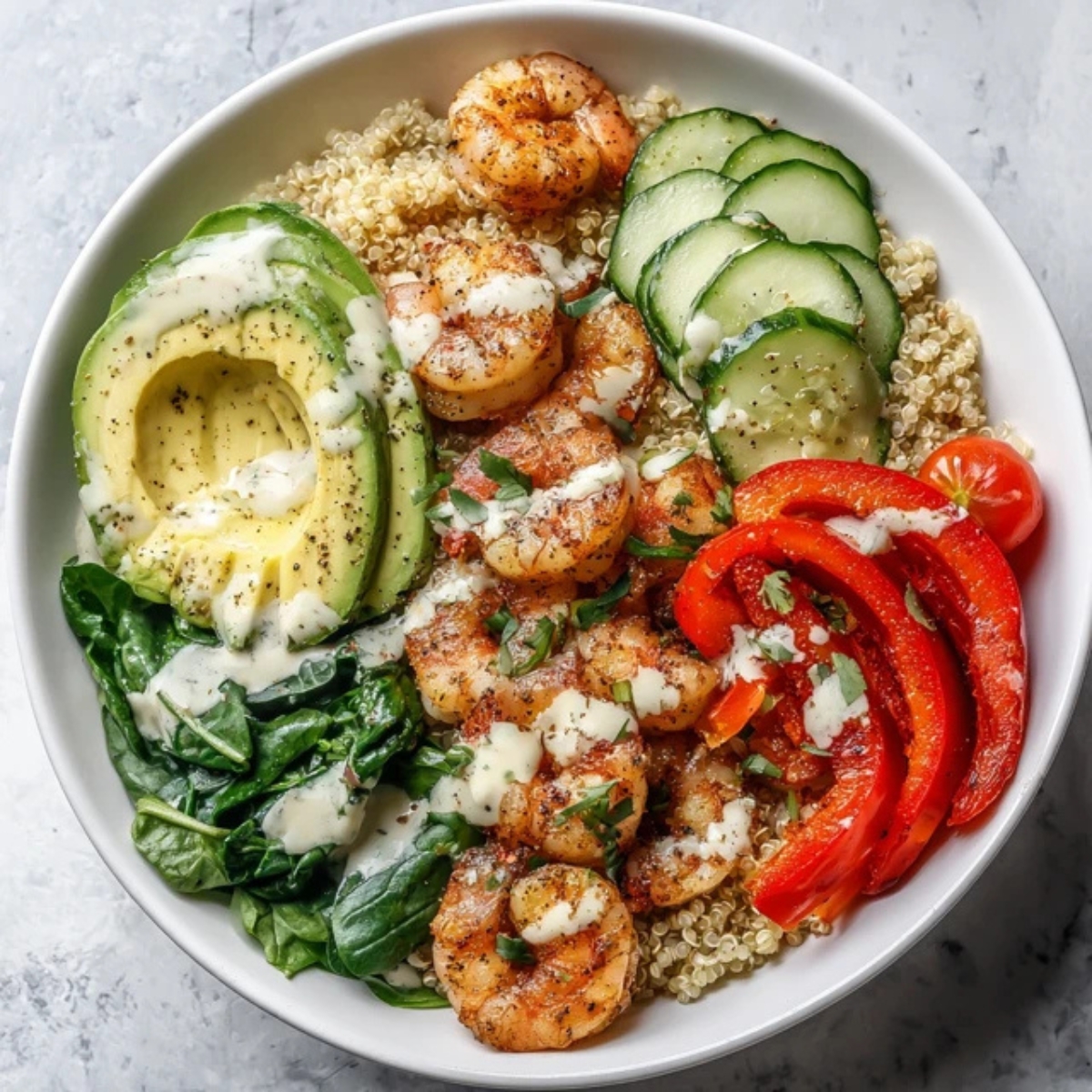 healthy shrimp quinoa bowl with fresh vegetables on white counter