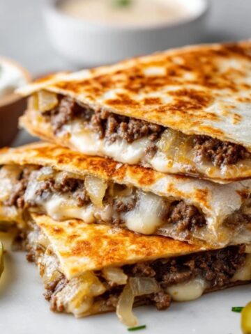 crispy smashburger quesadillas with melted cheese and caramelized onions on white kitchen counter