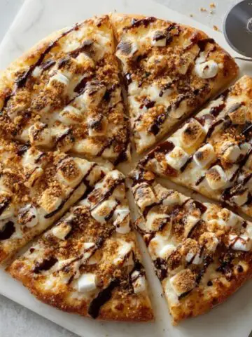 gooey chocolate marshmallow smores pizza on white kitchen counter