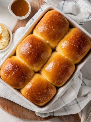 freshly baked texas roadhouse rolls with cinnamon honey butter on white kitchen counter