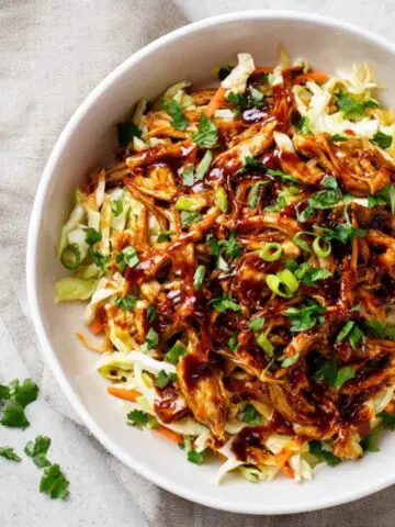 Homemade BBQ chicken coleslaw with creamy cabbage slaw on a white kitchen counter