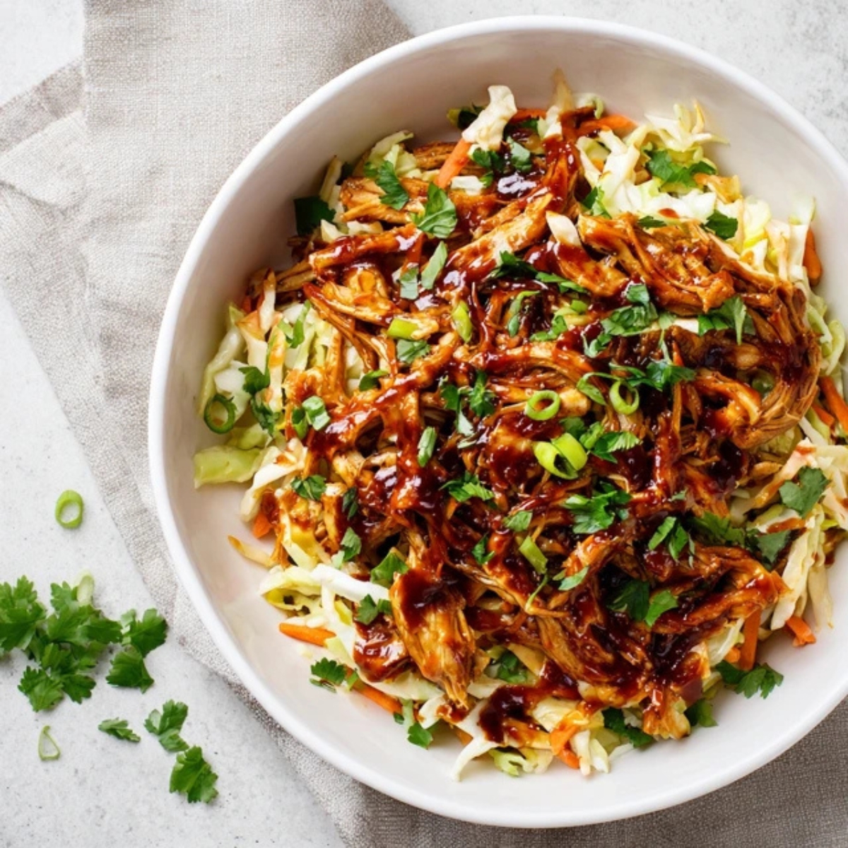 Homemade BBQ chicken coleslaw with creamy cabbage slaw on a white kitchen counter